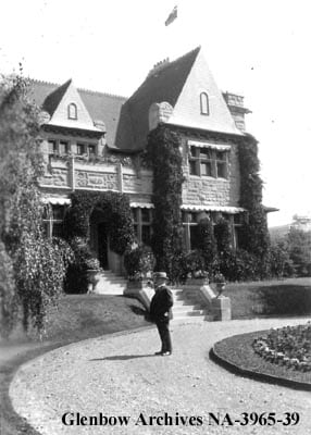 patrick burns standing outside his sandstone mansion in Calgary 